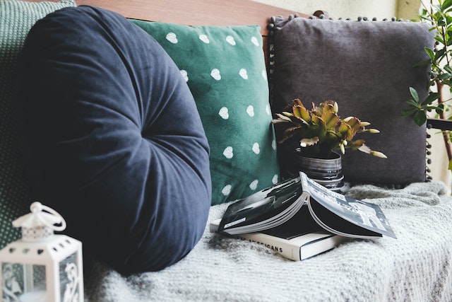 a couch with cushions and a book